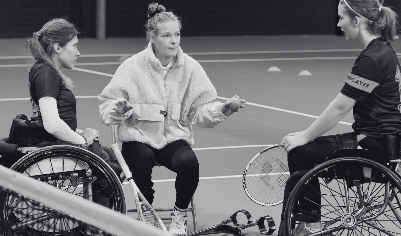 Diede de Groot geeft uitleg aan 2 rolstoeltennis meiden tijdens de Cruijff Foundation Junior Camp 2024